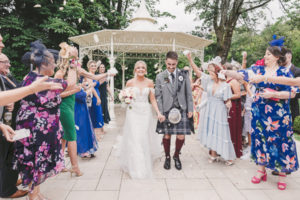 Bride and groom walking through confetti at Dalmeny Park