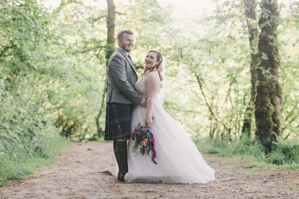 Bride and groom laughing in Trossachs woodland