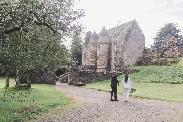 Bride and groom walking to the old Castle at Rowallan